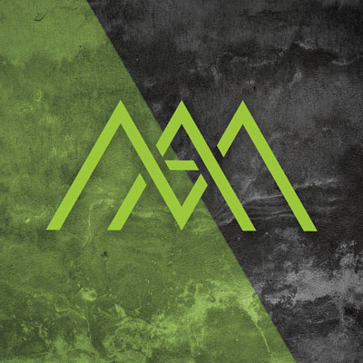 Bilde av den grønne logoen til Manstad Norge AS, på en mørkegrå betongbakgrunn, med et grønt felt over halve bildet, med 30 graders skeivhet.