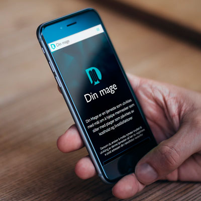 Bildet viser en hånd som holder en smarttelefon hvis skjerm viser nettsiden til Din Mage.